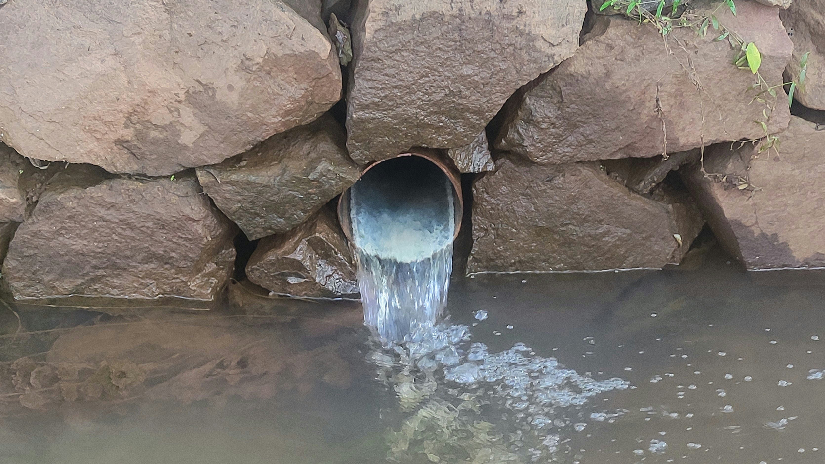 Water flows from a pipe into a canal