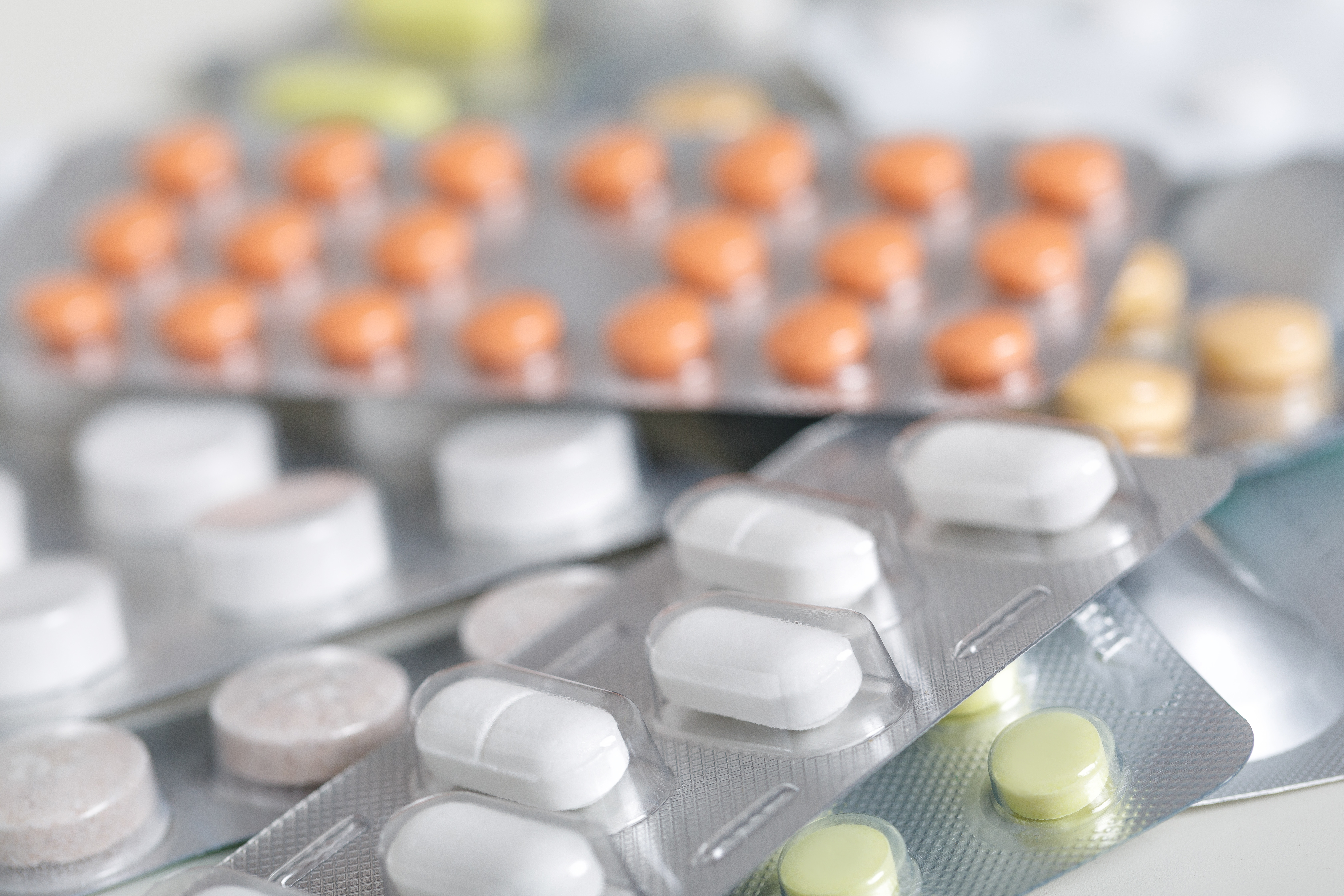 Several blister packs containing various tablets in different colors and shapes